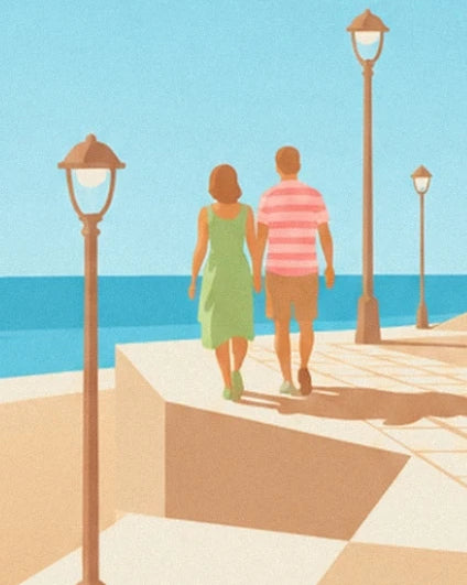 Un couple de dos sur la promenade en bord de mer, entre les lampadaires