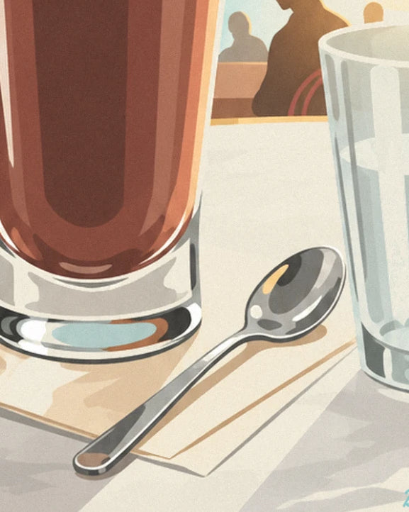 The metal teaspoon on the tablecloth between the coffee glass and the water glass