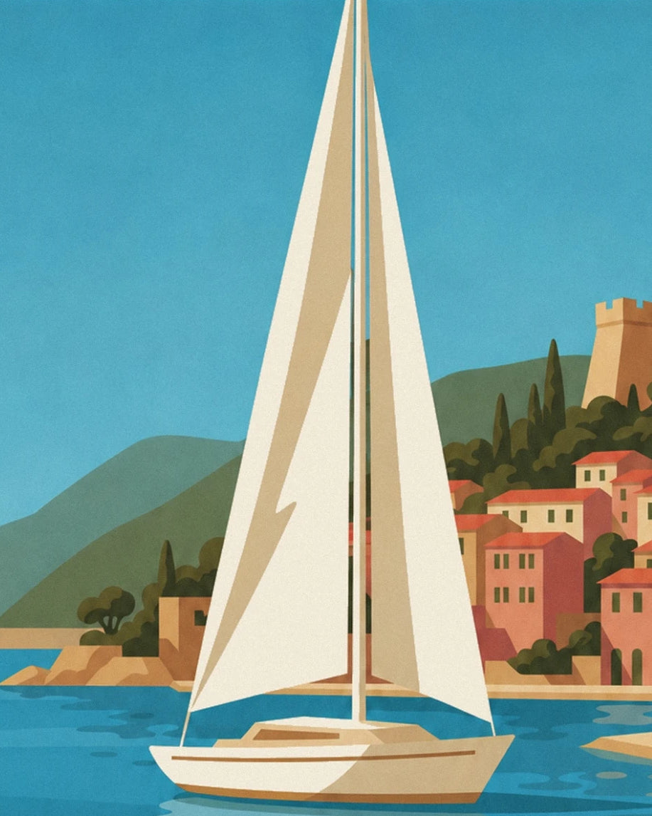 Le voilier aux voiles crème devant les façades colorées de Villefranche-sur-Mer