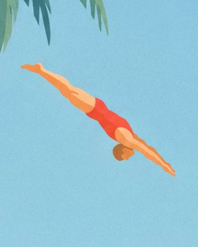 The diver in red trunks, head down and legs straight beneath the foliage