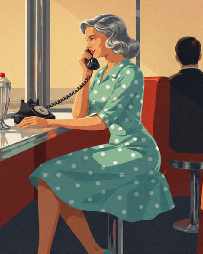 A woman in a green dress with white polka dots using a black telephone, seated at the diner counter