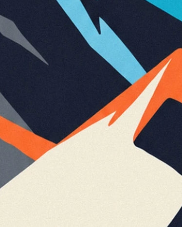 The creamy white slope and its orange ridge in front of midnight blue and light blue rock faces
