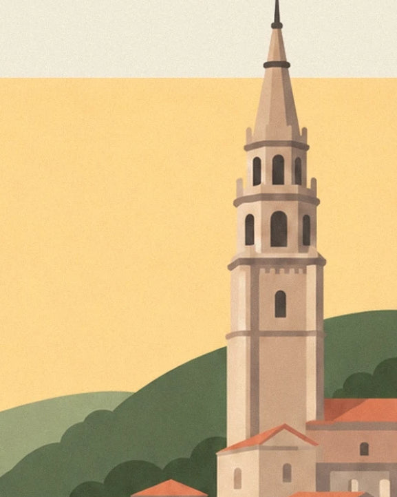 The slender bell tower of Mundaka with beige façades in front of the green hills