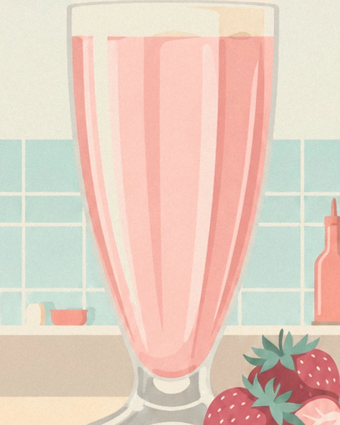 Un milk-shake rose dans un grand verre évasé, près des fraises sur le comptoir