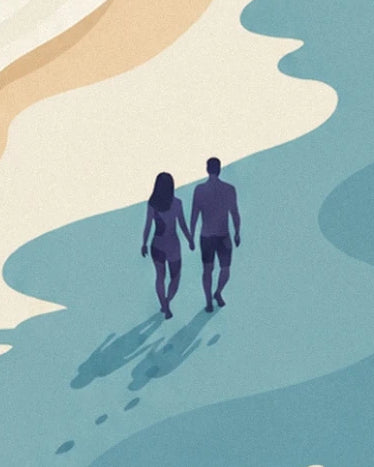 A couple holding hands at the water’s edge, with their long shadows on the sand