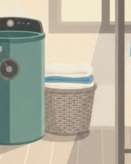 The green machine and its wicker basket filled with folded white and blue linen beside the window