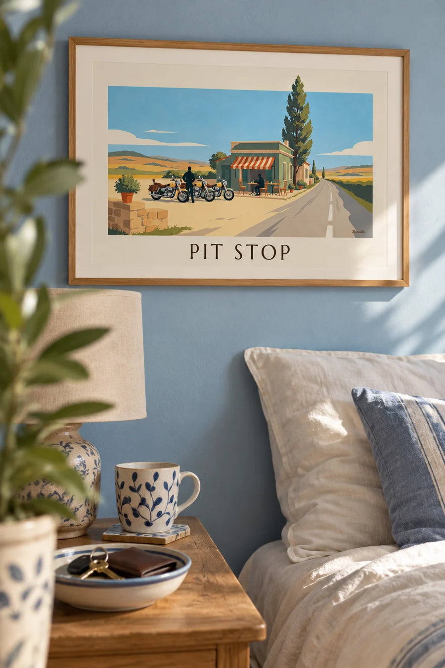Poster of motorcycles lined up in front of a roadside café: framed on the wall