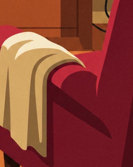 Le plaid crème drapé sur l’accoudoir du fauteuil rouge bordeaux