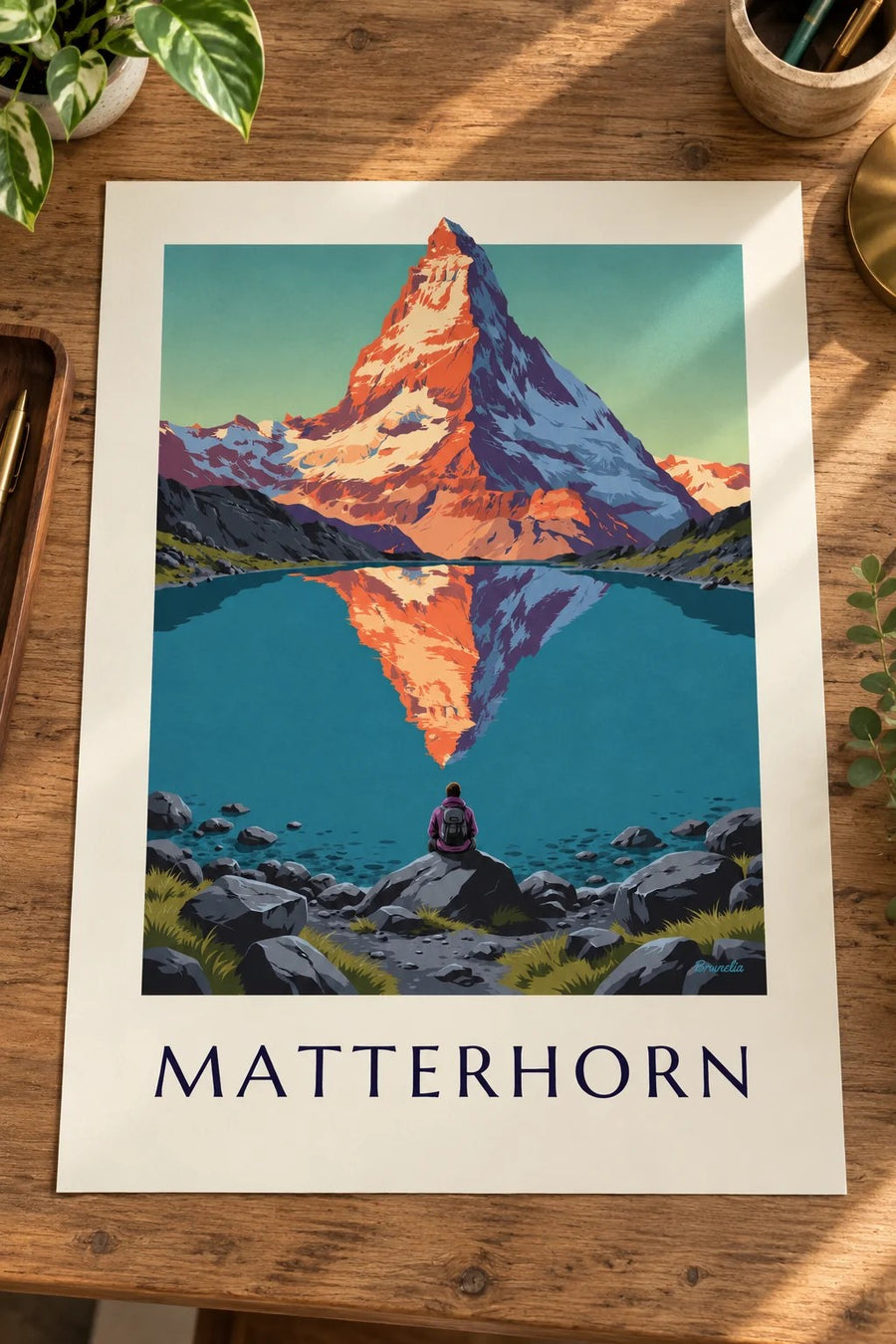 Plakat Matterhorn o zachodzie słońca odbity w alpejskim jeziorze: plakat oparty na stole