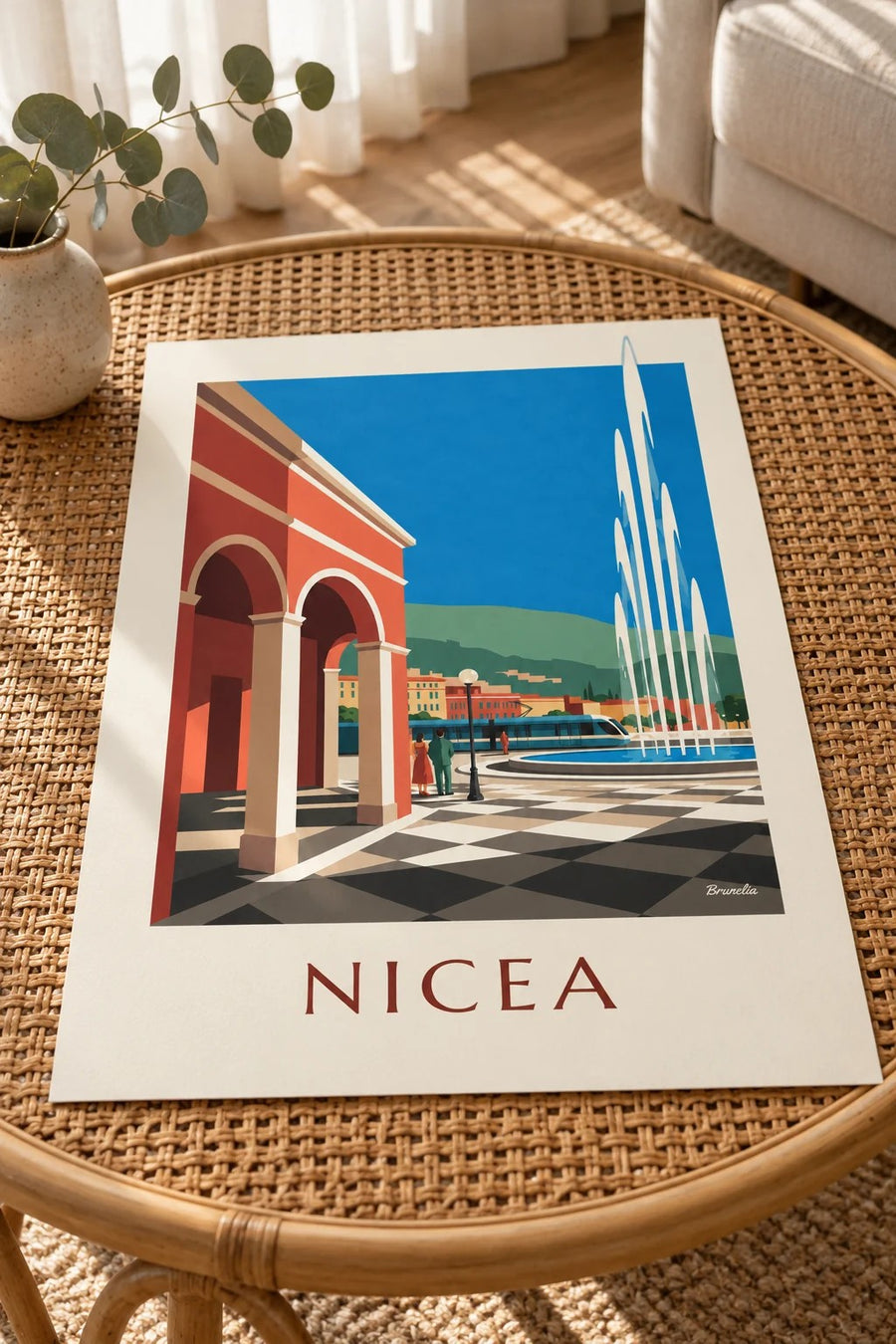 Plakat plac Masséna i czerwone fasady w Nicei: plakat oparty na stole