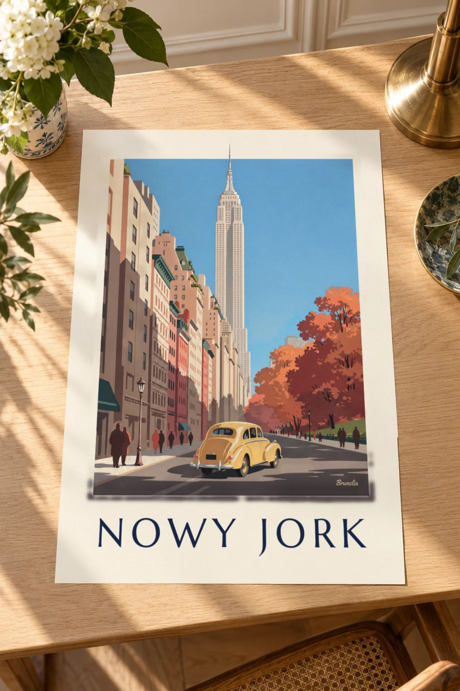 Plakat żółty samochód i Empire State Building jesienią: plakat leżący na stole