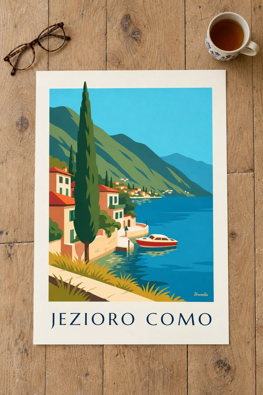 Plakat brzegi jeziora Como i drewniana łódź: na stole