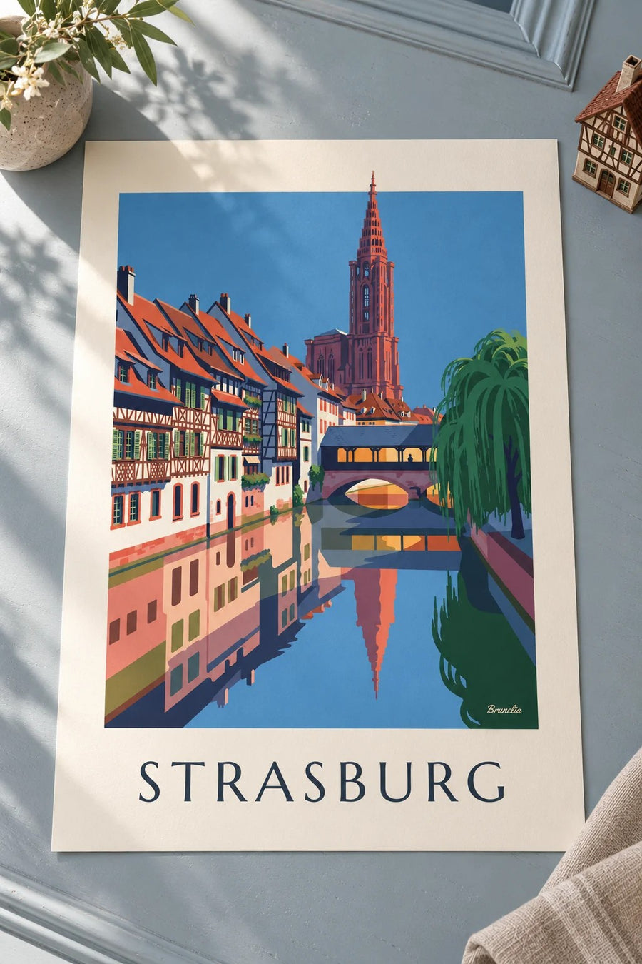 Plakat z domami z muru pruskiego i krytym mostem w Petite France w Strasburgu: plakat na stole
