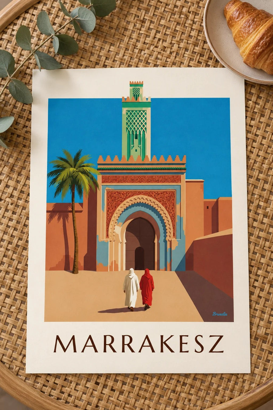 Plakat brama Bab Agnaou i minaret w Marrakeszu: leżący na stole